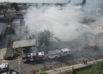 911 coordina asistencia de 21 unidades de bomberos para sofocar incendio afecta fábrica de tabaco en Moca