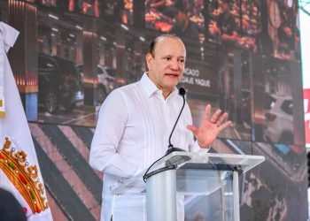 Alcaldía de Santiago inicia transformación y saneamiento del Hospedaje Yaque con inversión de RD$451 millones Santiago de los Caballeros .– La Alcaldía de Santiago de los Caballeros dejó iniciados este martes los trabajos para la transformación y saneamiento del Hospedaje Yaque, una obra esperada por muchos años y que hoy se hace posible gracias a la firme voluntad del presidente Luis Abinader y el Gobierno central, así como a la visión de la gestión municipal, con una inversión de RD$451,048,221.01. Al dejar iniciados los trabajos, el alcalde Ulises Rodríguez manifestó que la obra busca convertir el principal mercado de la región Norte en un espacio moderno, organizado, seguro y con mejores condiciones de higiene, beneficiando tanto a los comerciantes como a miles de consumidores que acuden diariamente al centro de abastecimiento. “Hoy no solo iniciamos una construcción. Hoy comenzamos a resolver un problema histórico de Santiago. Un problema que durante décadas afectó la salud pública, el comercio, la movilidad, el orden urbano y la imagen de nuestra ciudad. Hoy comenzamos a construir el mercado que los santiagueros merecen”, expresó el alcalde Ulises Rodríguez. El ejecutivo municipal destacó que la intervención busca resolver un problema histórico de la ciudad sin detener las actividades comerciales del mercado, mediante un proceso de diálogo con los vendedores y el respaldo del presidente Luis Abinader, para garantizar un Hospedaje Yaque moderno, seguro, organizado y con altos estándares de higiene y seguridad alimentaria. La presidenta de AMAPROSAN, Hilsa López, durante sus palabras de bienvenida, destacó que esta obra representa la respuesta a un reclamo histórico de Santiago, al fortalecer el comercio y dinamizar la economía local. Reconoció el respaldo del presidente Luis Abinader y el liderazgo del alcalde Ulises Rodríguez, reafirmando el compromiso de la institución de seguir impulsando iniciativas que promuevan el crecimiento de la ciudad. En nombre de los comerciantes del Hospedaje Yaque, Buenaventura Guzmán agradeció al presidente Luis Abinader por hacer realidad una obra largamente reclamada y reconoció el liderazgo del alcalde Ulises Rodríguez, subrayando que mientras anteriores administraciones ignoraron a esta comunidad, hoy el alcalde ha devuelto la voz y la paz a los trabajadores. Destacó que el proyecto será una bendición para Santiago, al fortalecer el comercio, generar empleos y consolidar la ciudad como destino turístico. La gobernadora de Santiago, Rosa Santos, afirmó que el primer picazo del Hospedaje Yaque representa la materialización de un sueño largamente esperado por los santiagueros. Destacó que el presidente Luis Abinader ha escuchado y atendido las necesidades de la provincia, garantizando seguridad y calidad de vida, y subrayó que en Ulises Rodríguez ha encontrado un aliado clave para trabajar como “un solo gobierno” en favor de la ciudad. Señaló que esta obra beneficiará tanto a grandes empresarios como a pequeños comerciantes y familias vulnerables, consolidando el desarrollo y la organización de uno de los espacios más emblemáticos de Santiago. El director de CORAASAN, Andrés Cueto, oriundo de la zona del Hospedaje Yaque, agradeció en nombre de los residentes y comerciantes del lugar la intervención de este espacio, calificándola como un sueño hecho realidad. Reconoció públicamente al alcalde Ulises Rodríguez como el mejor alcalde que ha tenido Santiago, destacando su liderazgo histórico y las obras de gran impacto que está transformando la ciudad junto al respaldo del presidente Luis Abinader. Subrayó que “hay alcalde para mucho tiempo más” y que la gestión de Ulises marca un antes y un después en el desarrollo de Santiago, con proyectos de primer nivel que dignifican a la comunidad. La obra contempla la construcción de una moderna edificación comercial de dos niveles y un nivel soterrado, con una superficie total de 13,713 metros cuadrados de construcción, complementada con 6,490 metros cuadrados de espacio público que incluirán calles circundantes, aceras, contenes, arborización y mobiliario urbano para mejorar el entorno. Los trabajos incluyen la demolición de las estructuras existentes, la adecuación del terreno y la ejecución de una nueva infraestructura de hormigón armado y acero estructural. El edificio dispondrá de oficinas administrativas, módulos comerciales, áreas para venta de alimentos, carnicería, pescadería, almacenes, baños, vestidores, ascensores y amplios espacios comunes diseñados para ofrecer mayor funcionalidad y comodidad. Asimismo, incorporará modernos sistemas eléctricos, hidrosanitarios, contra incendios, climatización, drenaje pluvial y redes de datos, además de vías de acceso, parqueos, áreas verdes y paisajismo. Con esta intervención se busca fortalecer la infraestructura comercial, dinamizar la economía local y ofrecer a comerciantes y visitantes un espacio moderno, seguro y eficiente.